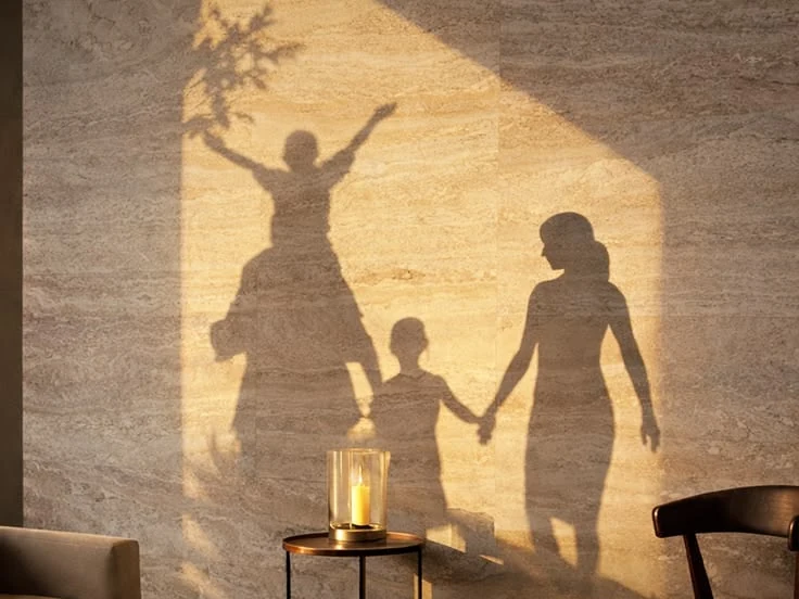 A family's shadow in warm light on a marble wall